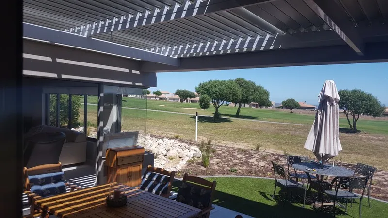Adjustable louvre awning over an outdoor living area