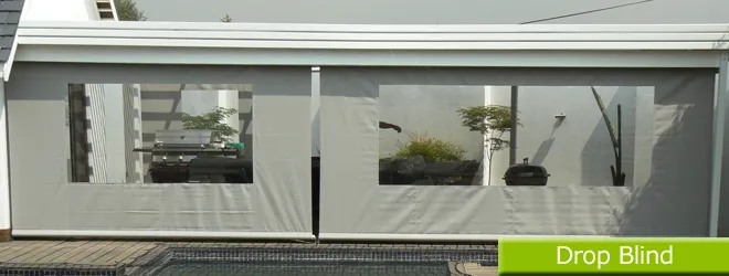Drop blind with clear PVC window enclosing the side of a covered patio