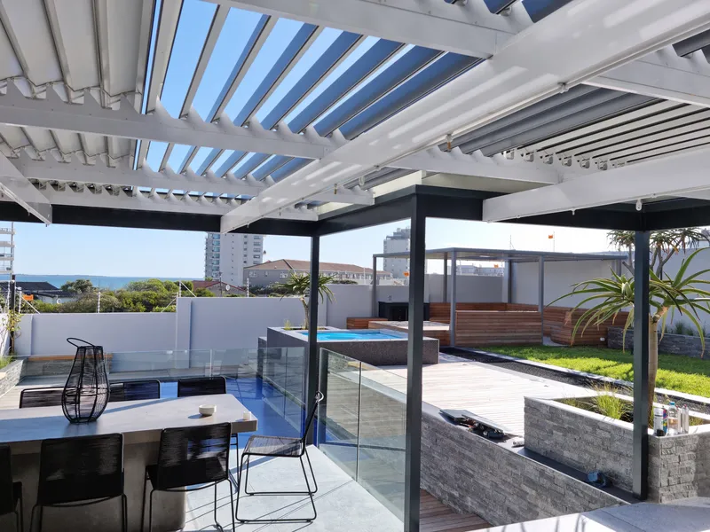 Open louvres over a rooftop patio with sea views