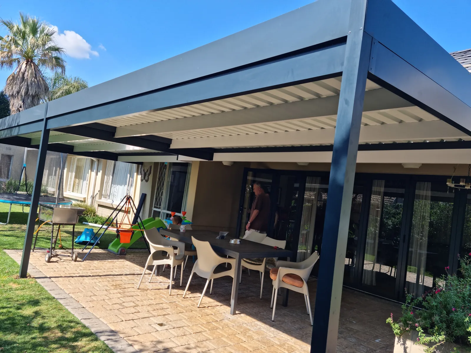 Fixed aluminium IBR patio cover over an outdoor dining area in Johannesburg